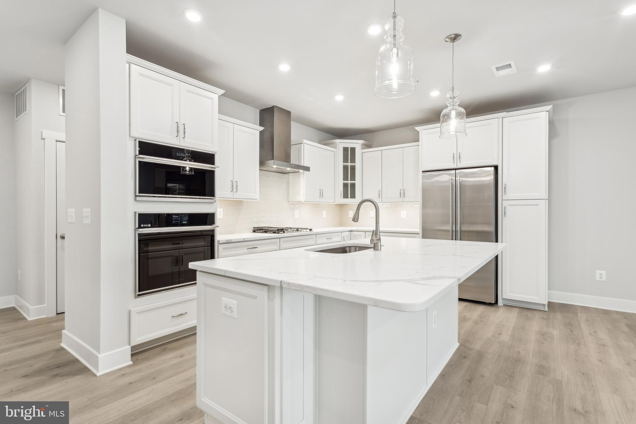 630 Warbler Way, Unit 2212 Chester, MD 21619 - Photo 15 of 73 a kitchen with kitchen island a sink stainless steel appliances and cabinets