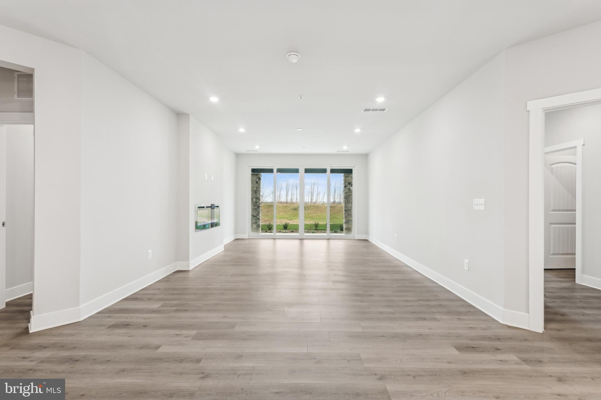 630 Warbler Way, Unit 2212 Chester, MD 21619 - Photo 22 of 73 a view of an empty room with wooden floor and a window