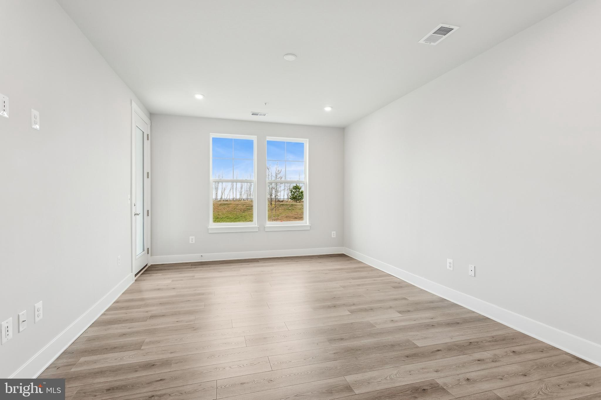 630 Warbler Way, Unit 2212 Chester, MD 21619 - Photo 44 of 73 a view of an empty room with wooden floor and a window