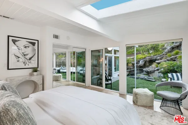 a bedroom with a bed large window and a couch