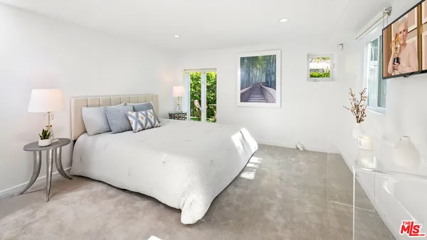 a bedroom with a bed and painting on the wall