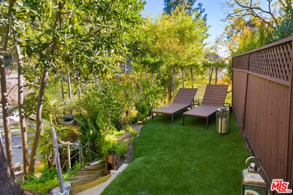 a view of a backyard with table and chairs and potted plants