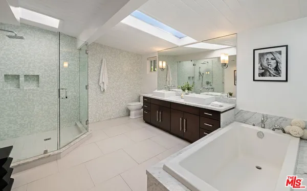 a bathroom with a tub sink and mirror