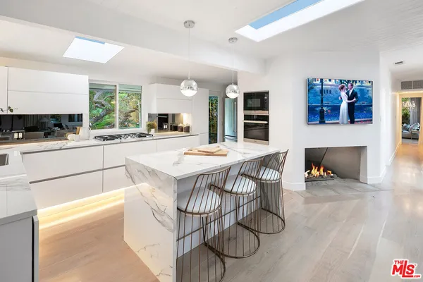 a kitchen with a table chairs in it and wooden floors