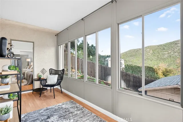 a living room with furniture potted plant and a large window