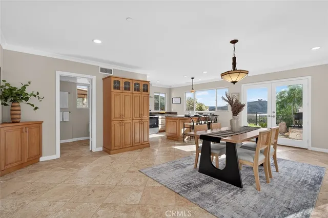 a dining room with wooden floor a chandelier a wooden table and chairs