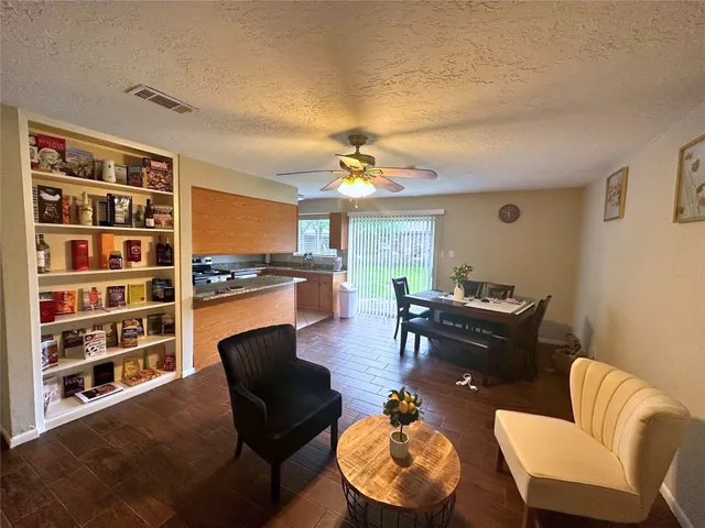 a living room with furniture kitchen view and a large window