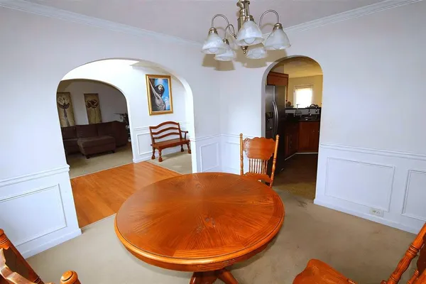 a view of a dining room with furniture and a chandelier
