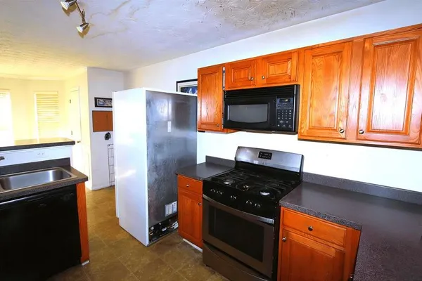 a kitchen with stainless steel appliances a stove and a microwave