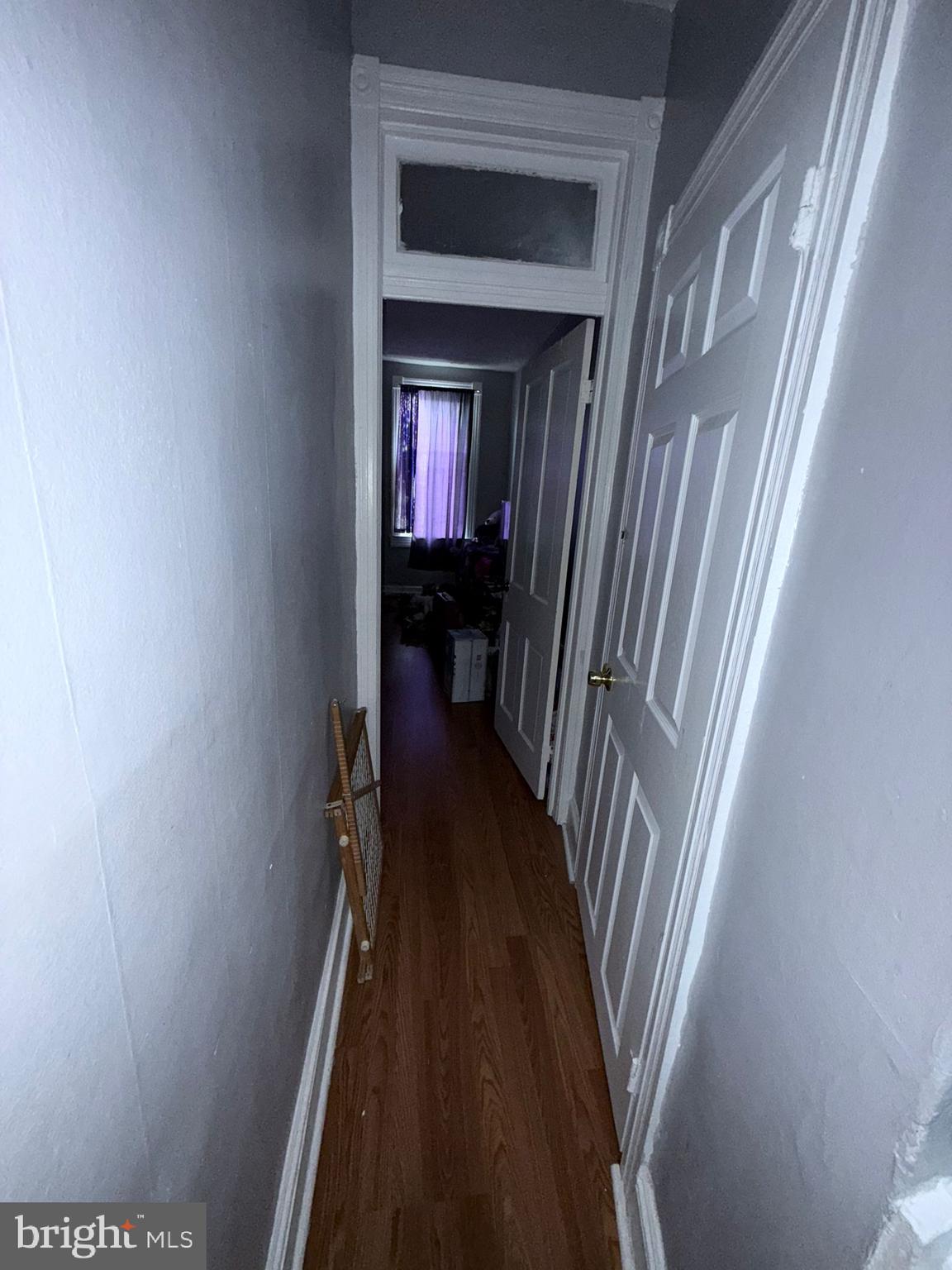 2117 Penrose Avenue Baltimore, MD 21223 - Photo 19 of 30 a view of a hallway with wooden floor and a bathroom