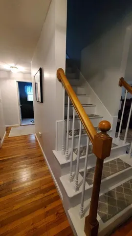 a view of entryway and hall with wooden floor
