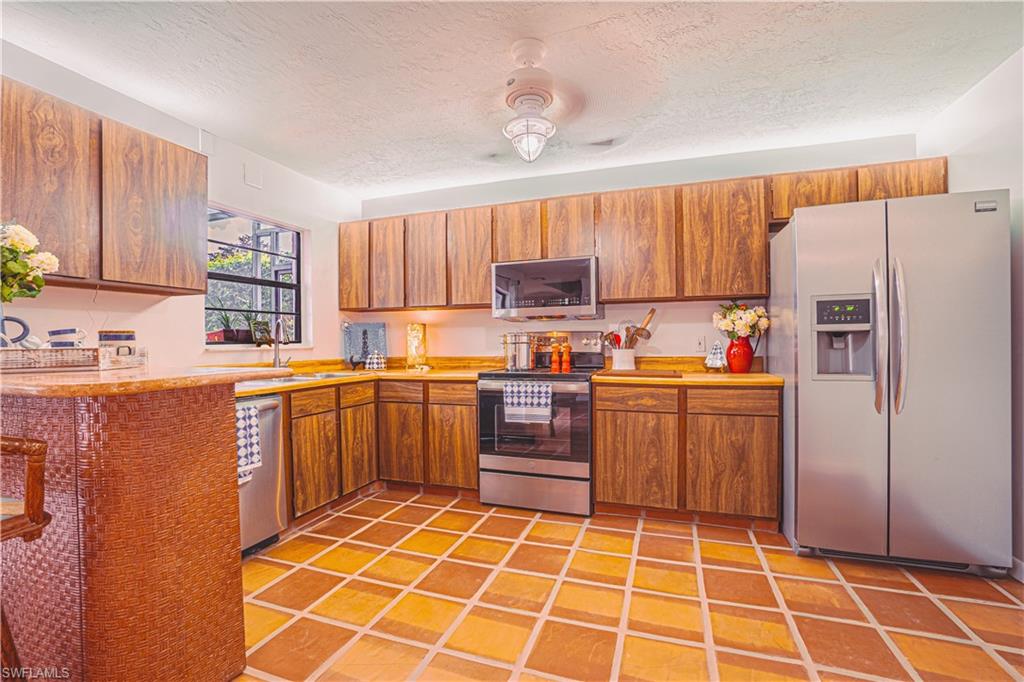 200 Marseille Drive, Unit 12A Naples, FL 34112 - Photo 1 of 36 a kitchen with a refrigerator sink and cabinets