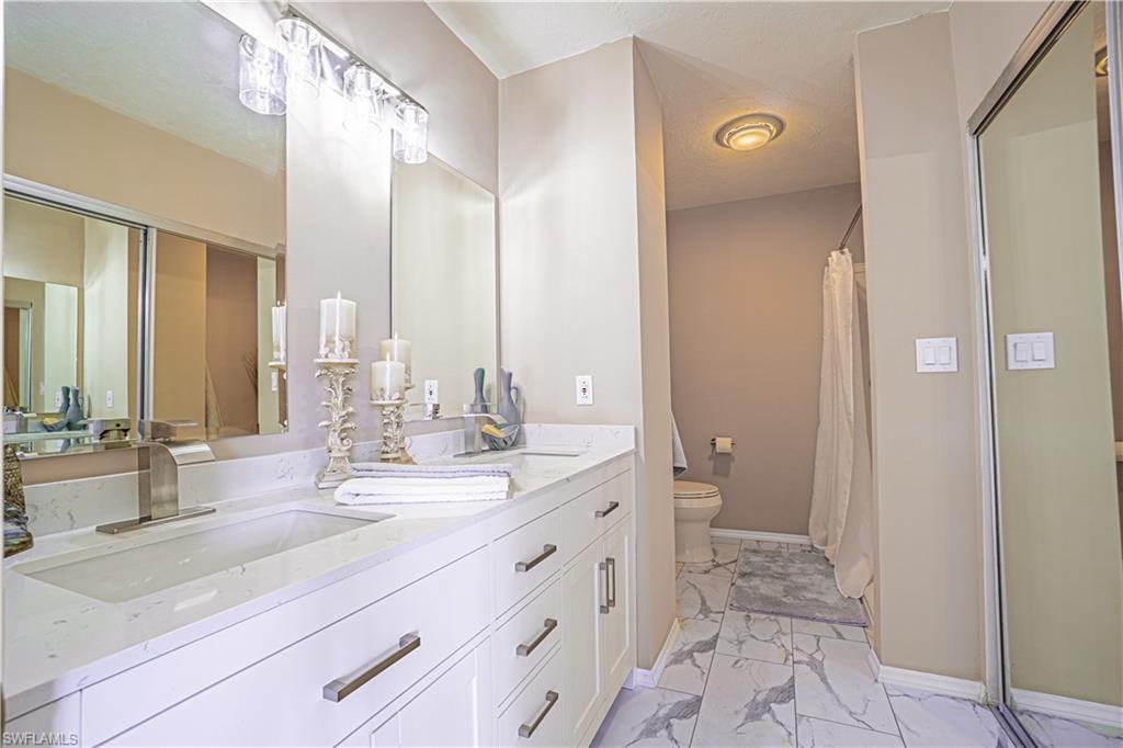 200 Marseille Drive, Unit 12A Naples, FL 34112 - Photo 19 of 36 a bathroom with a double vanity sink and a mirror