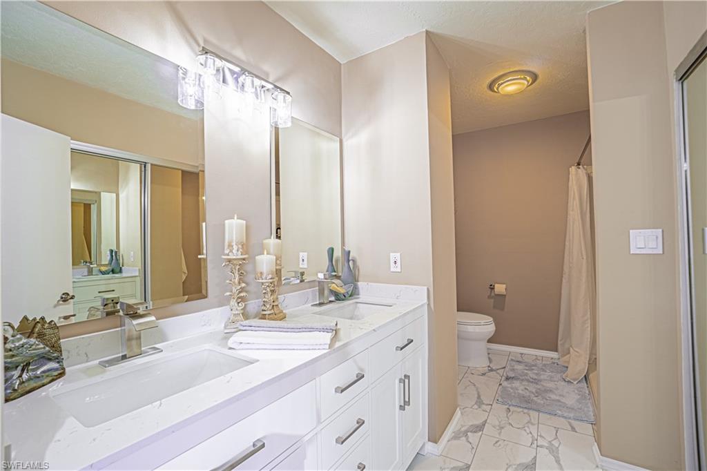200 Marseille Drive, Unit 12A Naples, FL 34112 - Photo 23 of 36 a bathroom with a double vanity sink mirror and toilet