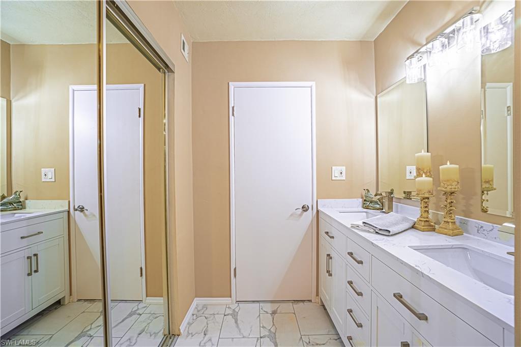 200 Marseille Drive, Unit 12A Naples, FL 34112 - Photo 24 of 36 a bathroom with a double vanity sink and a mirror