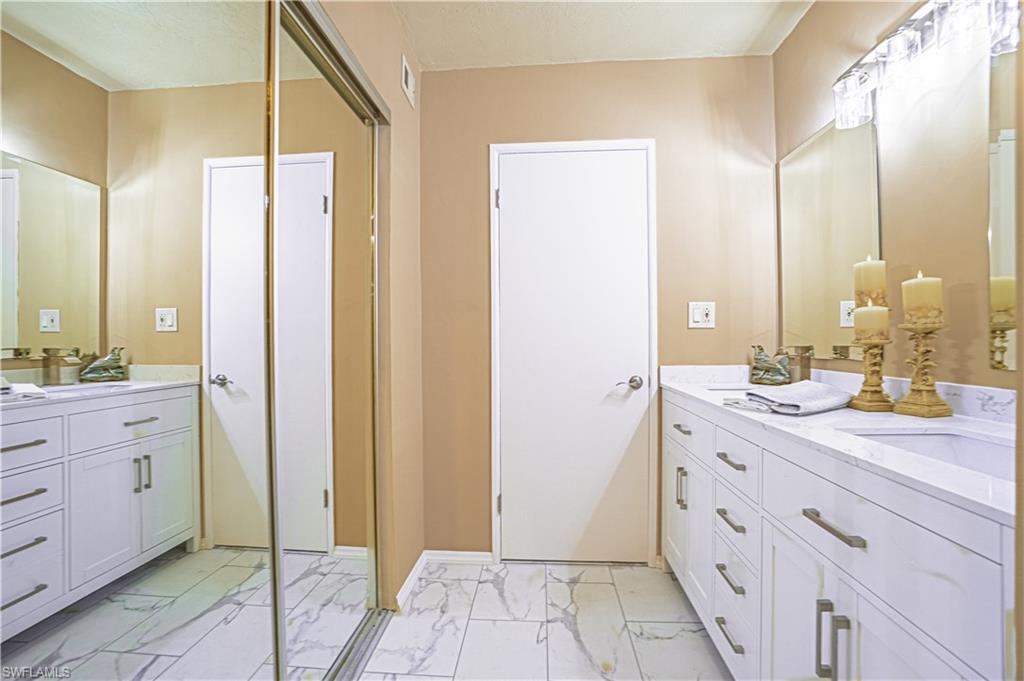 200 Marseille Drive, Unit 12A Naples, FL 34112 - Photo 25 of 36 a spacious bathroom with a double vanity sink a mirror and a shower