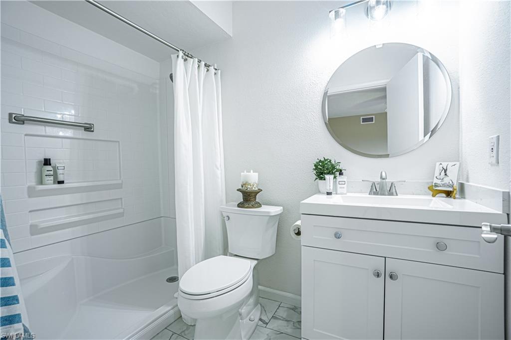 200 Marseille Drive, Unit 12A Naples, FL 34112 - Photo 29 of 36 a bathroom with a sink toilet and a mirror