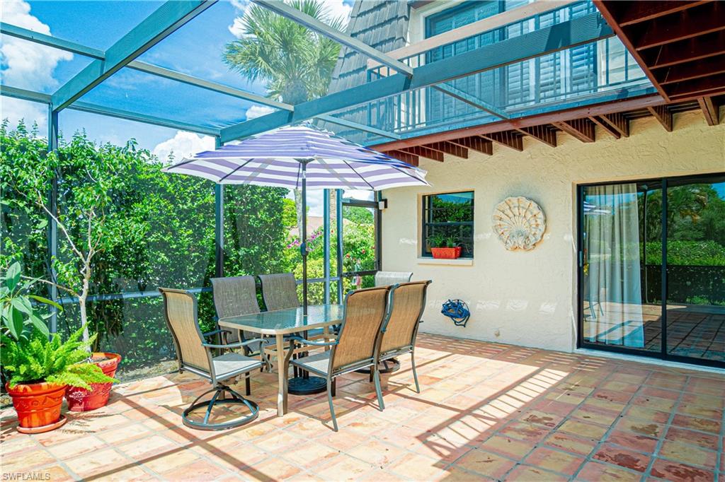 200 Marseille Drive, Unit 12A Naples, FL 34112 - Photo 32 of 36 a patio with a table and chairs and potted plants