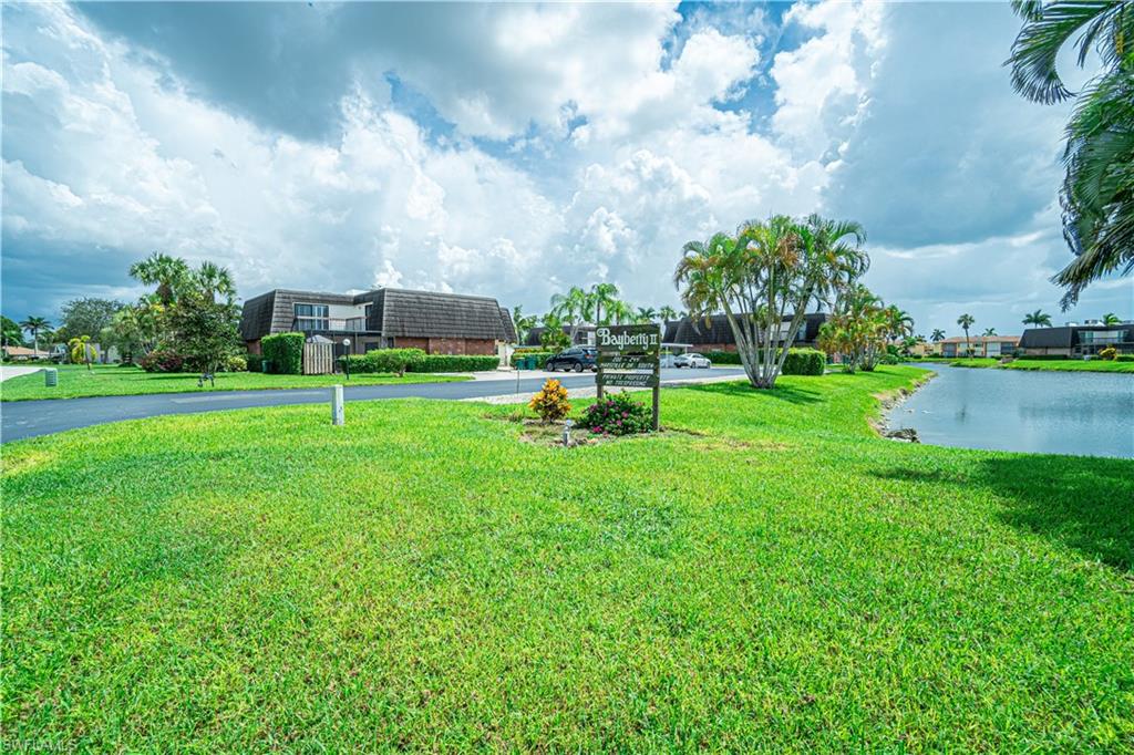200 Marseille Drive, Unit 12A Naples, FL 34112 - Photo 34 of 36 a garden with trees and buildings in the background