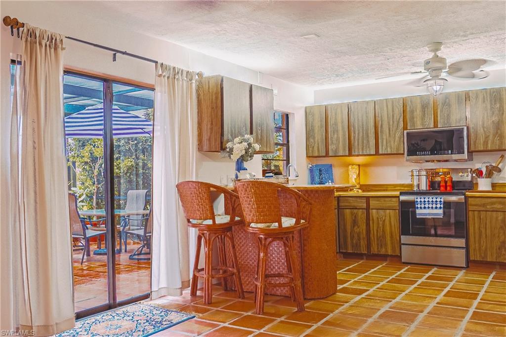 200 Marseille Drive, Unit 12A Naples, FL 34112 - Photo 7 of 36 a kitchen with stainless steel appliances a stove refrigerator sink and microwave