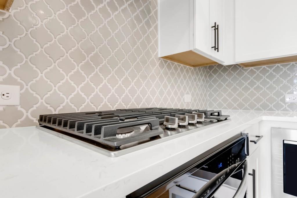 923 Echo Pk Drive Suwanee, GA 30024 - Photo 13 of 26 an oven sitting inside of a kitchen with granite countertop white cabinets and wooden floor