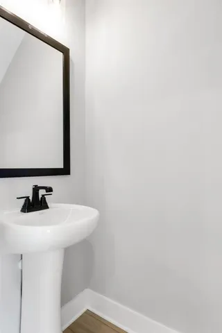 a bathroom with a bathtub shower sink vanity mirror and toilet