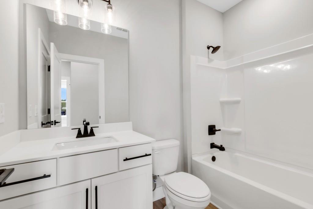 923 Echo Pk Drive Suwanee, GA 30024 - Photo 16 of 26 a bathroom with a bathtub shower sink vanity mirror and toilet