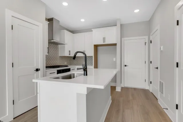 a kitchen with stainless steel appliances a sink stove and cabinets