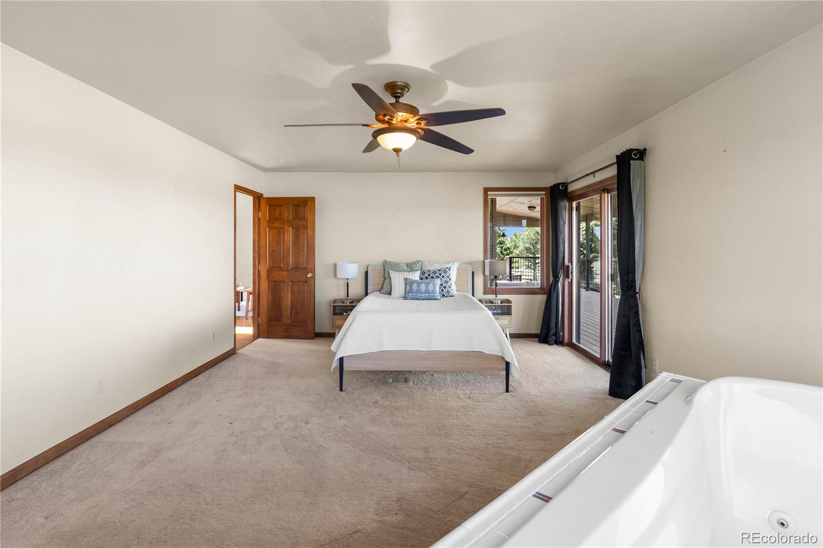 74 Rocky Cliff Road Elizabeth, CO 80107 - Photo 23 of 50 a spacious bedroom with a bed and ceiling fan