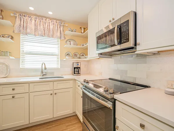 a kitchen with white cabinets and a sink