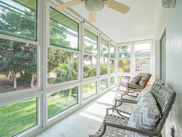 a living room with furniture and floor to ceiling windows