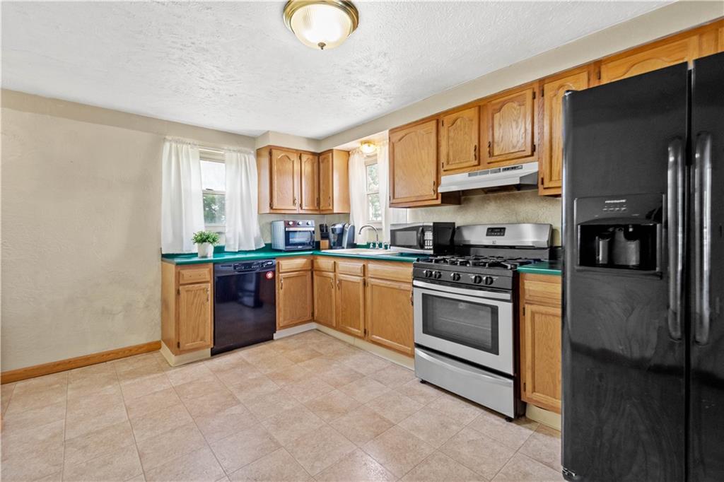 3406 McRoberts Road Pittsburgh, PA 15234 - Photo 5 of 19 a kitchen with stainless steel appliances granite countertop a stove top oven a sink dishwasher and a refrigerator