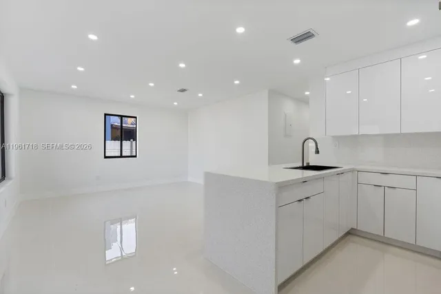 a kitchen with sink a microwave and cabinets