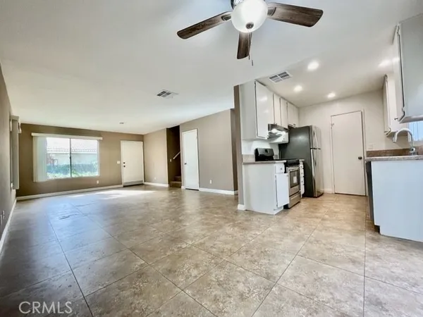 a view of a kitchen with refrigerator and a stove top oven