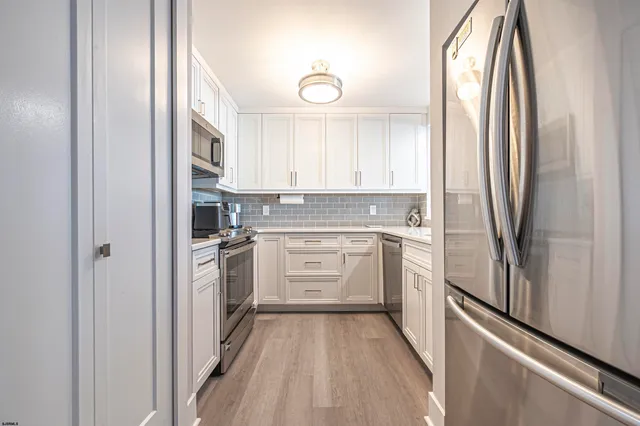 a kitchen with white cabinets and sink