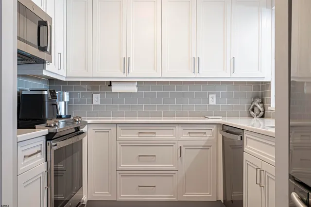 a kitchen with cabinets stainless steel appliances and a counter space