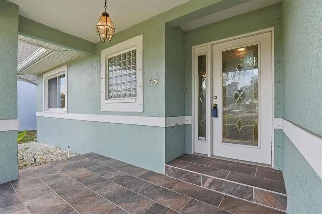 a view of a hallway with windows and chandelier