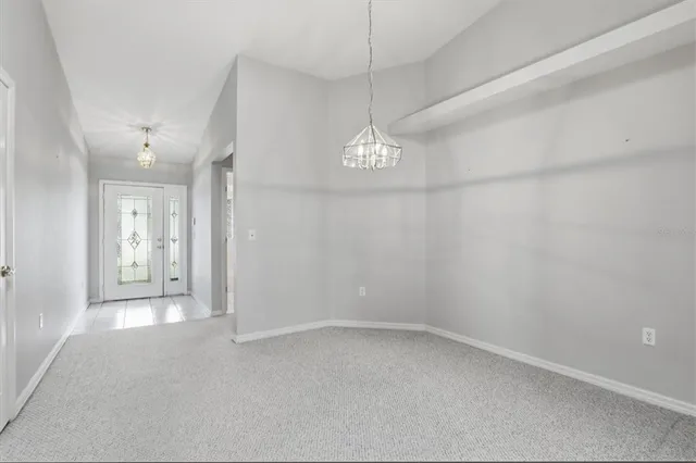 en empty room with windows and chandelier