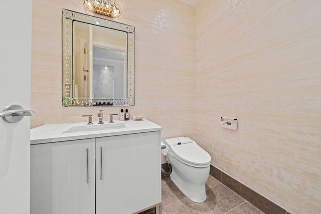 a bathroom with a granite countertop toilet a sink and mirror