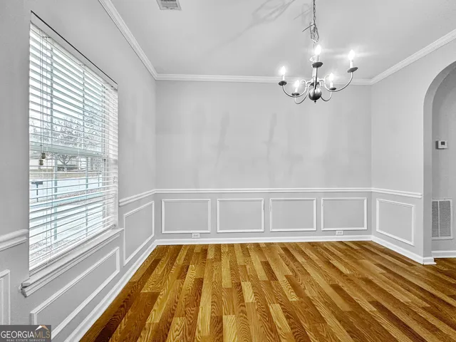 a view of a room with wooden floor and chandelier