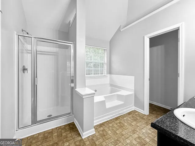 a bathroom with a tub shower and a sink