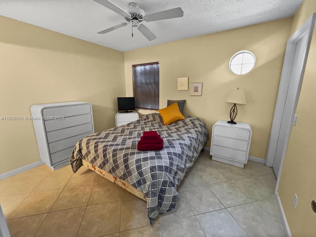 369 Waterside Drive, Unit 369 Hypoluxo, FL 33462 - Photo 17 of 23 a bedroom with a bed and a lamp