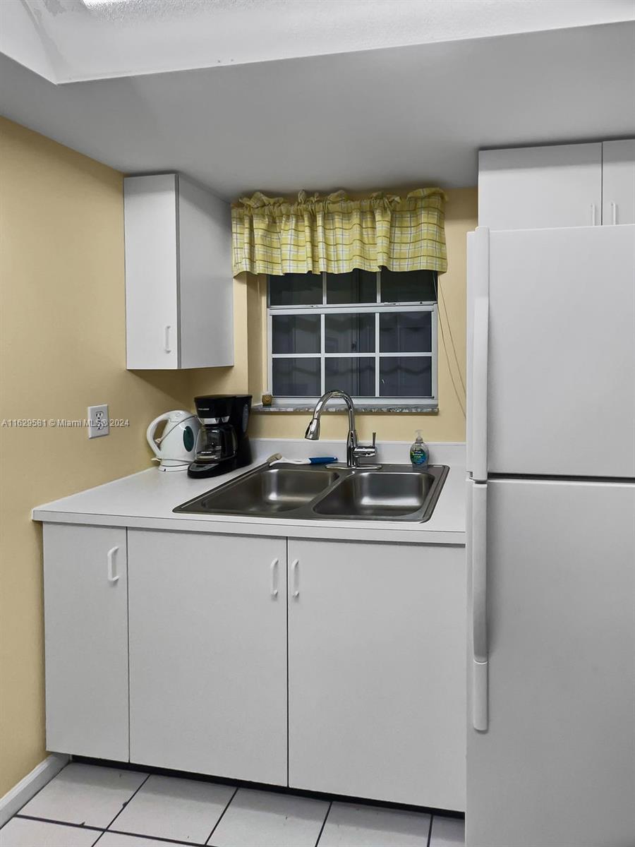 369 Waterside Drive, Unit 369 Hypoluxo, FL 33462 - Photo 6 of 23 a kitchen with stainless steel appliances granite countertop a sink and a white refrigerator