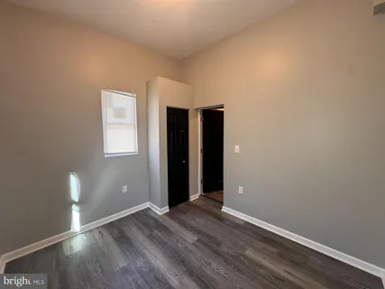 an empty room with wooden floor and closet