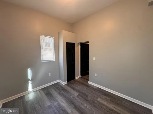 an empty room with wooden floor and closet