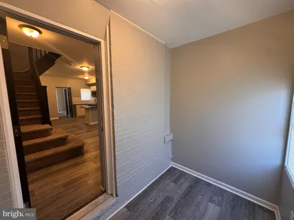 a view of a hallway with entryway wooden floor and front door