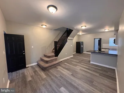 a view of a living room with furniture and a wooden floor