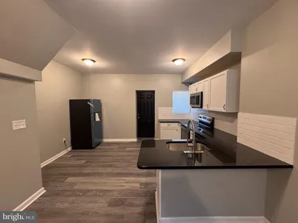 a kitchen with kitchen island a counter top space a sink and stainless steel appliances