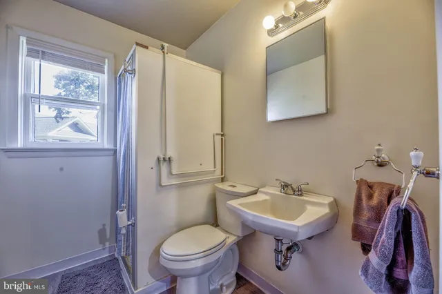 a bathroom with a sink toilet and a mirror