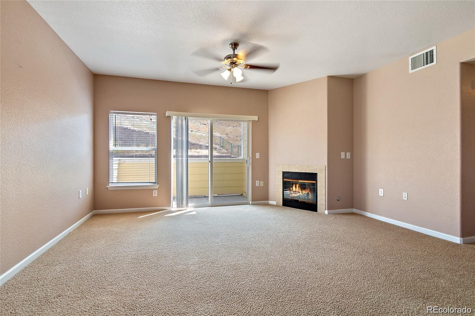 5534 Lewis Street, Unit 206 Arvada, CO 80002 - Photo 4 of 27 a view of an empty room with a fireplace and a window